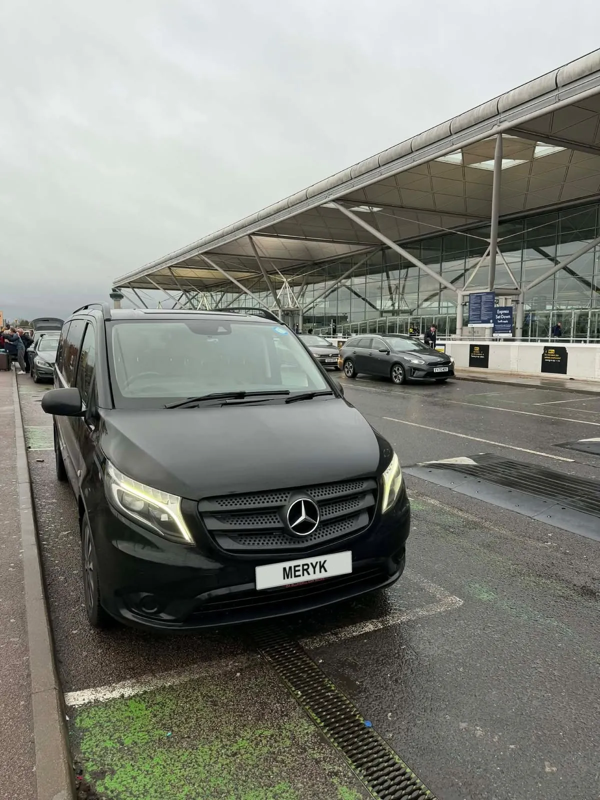 MERYK Executive Transfers Mercedes people carrier waiting outside an airport terminal